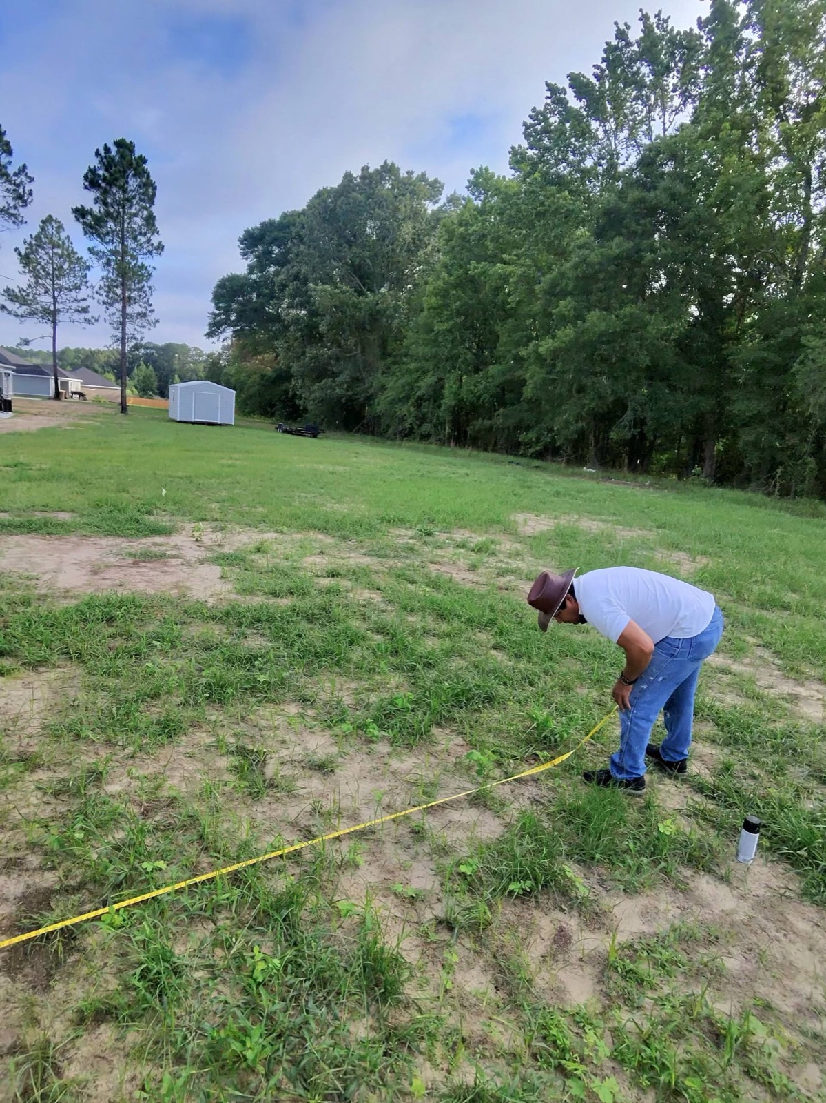 Global Finishes measuring and laying out a concrete patio in a Savannah GA backyard