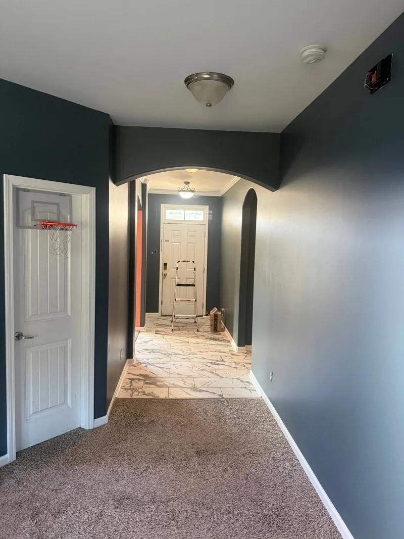 Same hallway painted deep blue with white trim