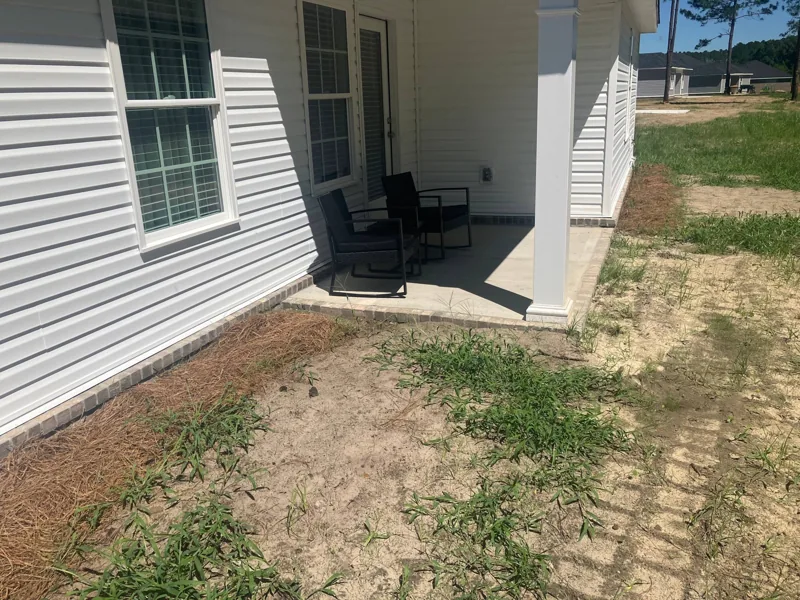 Bare dirt beside a porch before the concrete pour