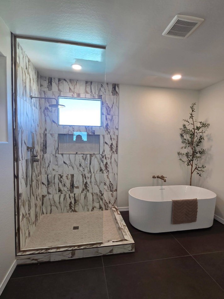 Marble shower with freestanding ribbed tub and olive tree