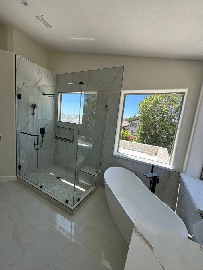 Frameless glass shower with freestanding tub and large window