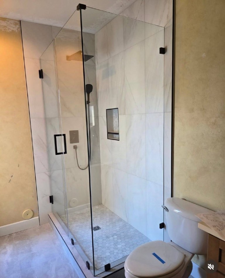 Glass shower install with marble tile and pre-paint yellow walls