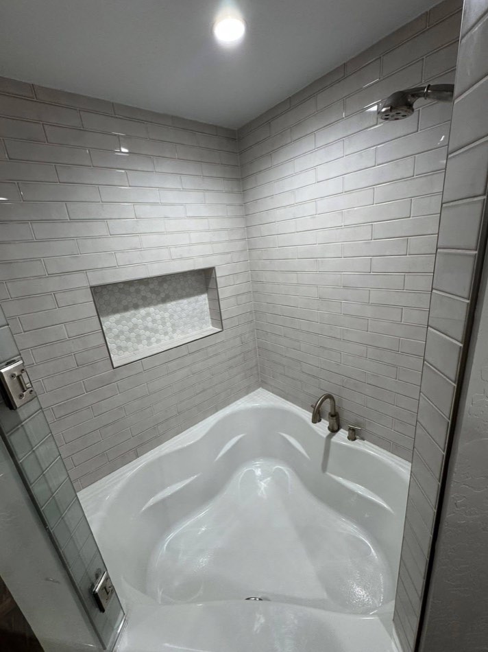 Subway tile shower-tub combo with mosaic niche accent