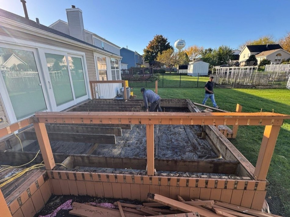 Deck rebuild in progress with exposed joists and crew
