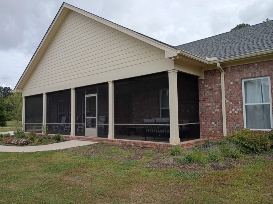Long screened porch on a Lowcountry home with rocking chairs