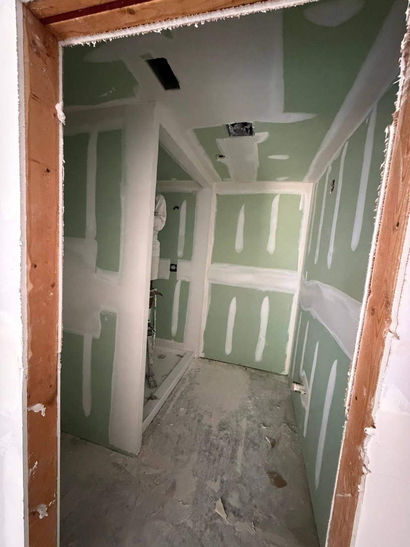 Green moisture-board bathroom with white mud bands on every seam