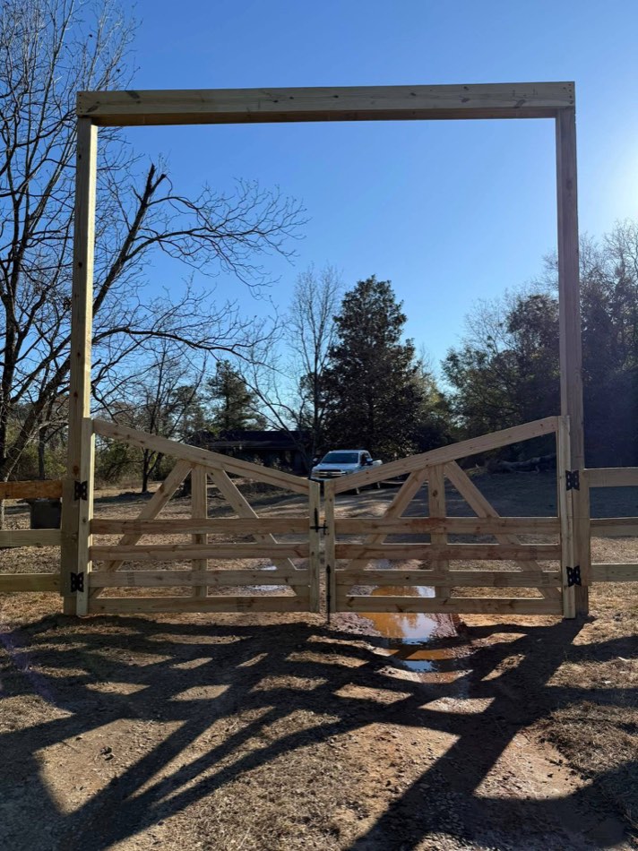 Timber-frame entrance arch with double swing gates on a Lowcountry property