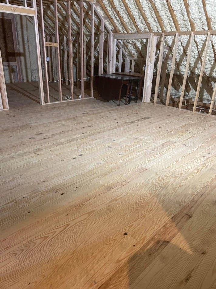 Fresh pine planks laid in framed attic space