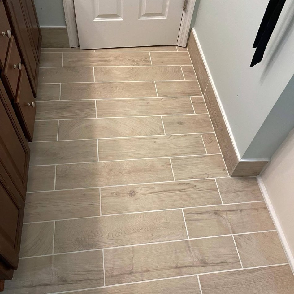 Wood-look tile install with vanity edge visible
