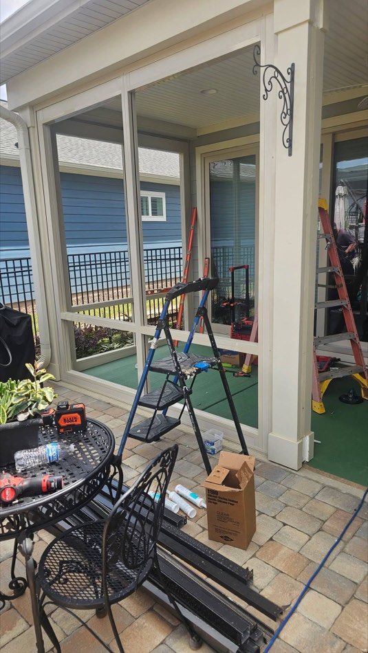 Active sunroom jobsite with ladders and tools mid-build