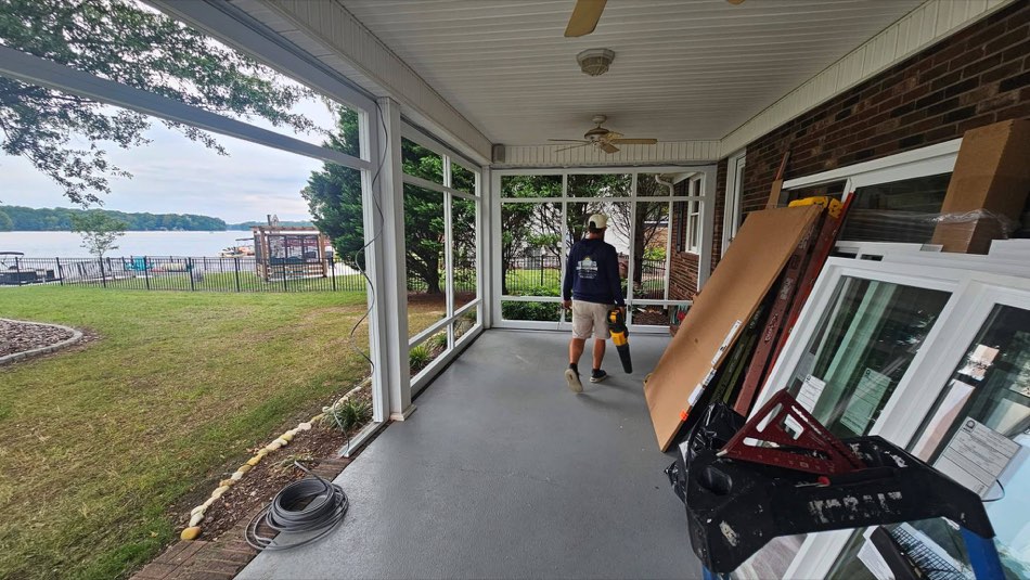Sunroom with crew member installing window panels on a Lowcountry lakeside property